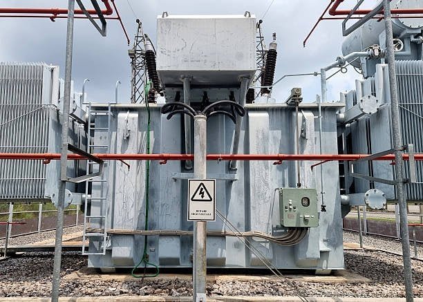 High-voltage power transformer at a substation, showcasing electrical insulation and safety features, essential for efficient electricity transmission and distribution.