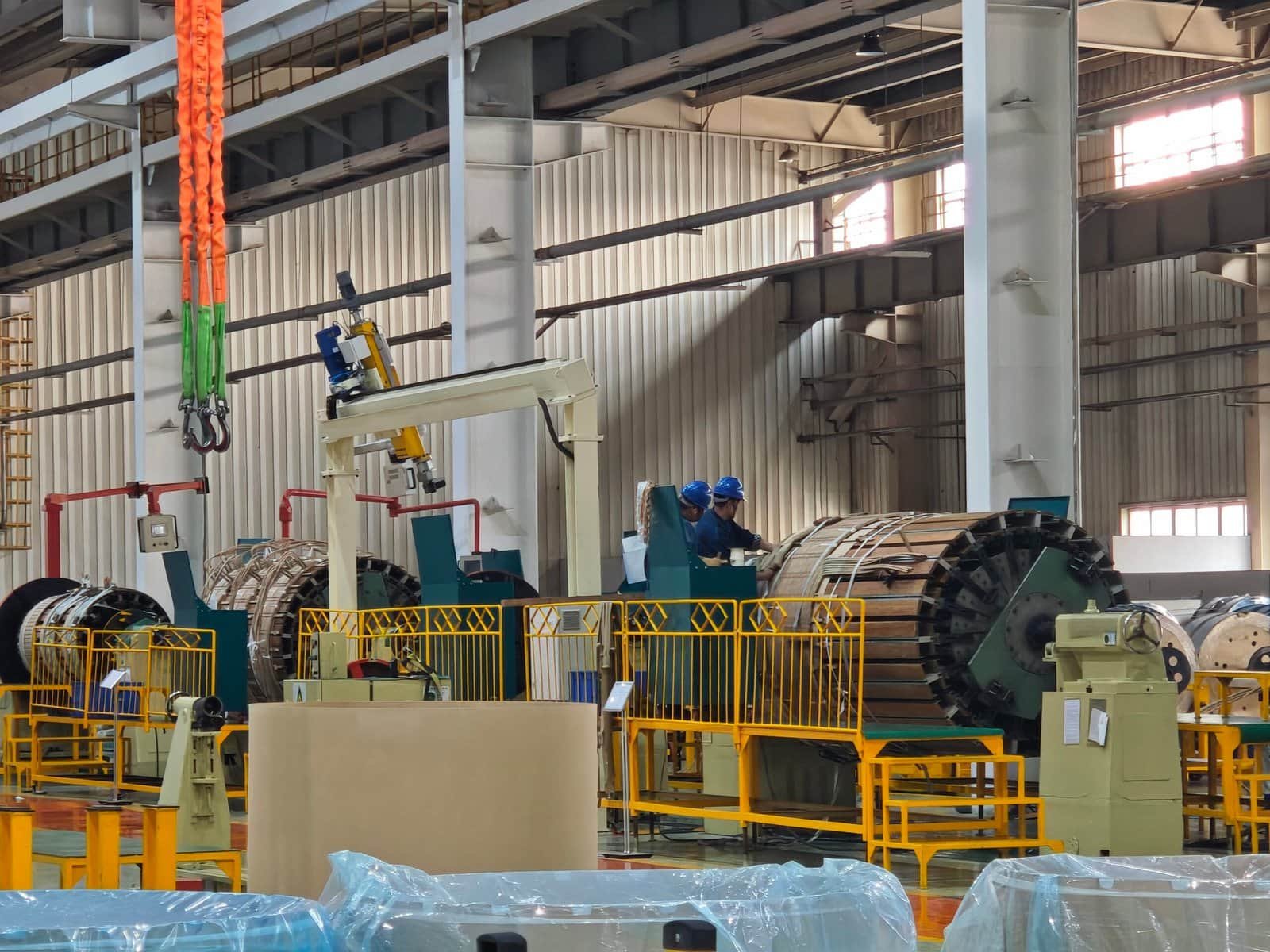 High-capacity industrial transformer being assembled in a manufacturing facility, showcasing advanced electrical engineering and manufacturing processes.