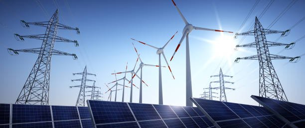 Renewable energy scene with wind turbines, solar panels, and power lines under a clear blue sky.